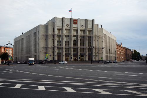 Free A large government building with a flag at a major urban intersection on an overcast day. Stock Photo