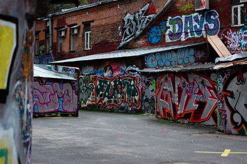 Free Explore colorful street art in a gritty urban alleyway, showcasing dynamic graffiti and industrial vibes. Stock Photo