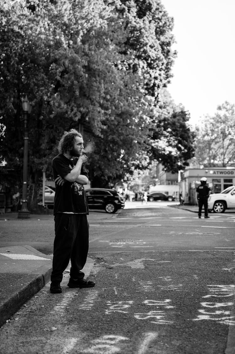 Standing On Street Man Smoking A Cigarette