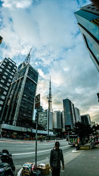 Dynamic urban scene with modern skyscrapers under a vibrant sky, showcasing urban life.