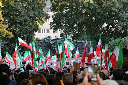 Crowd of People Protesting with Iranian Flags