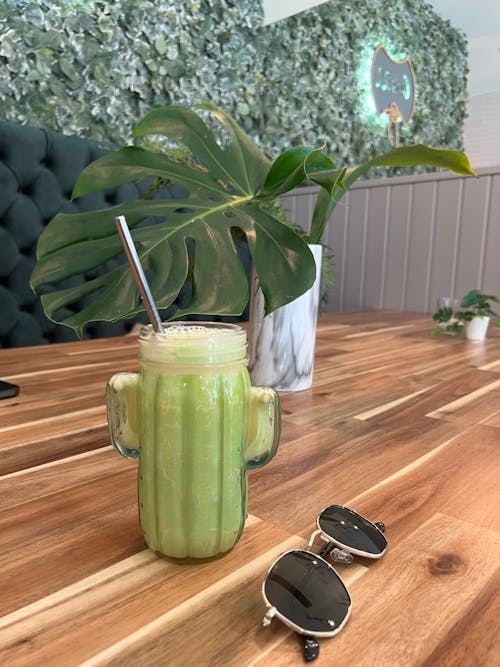 Green Juice with a Straw on a Wooden Table