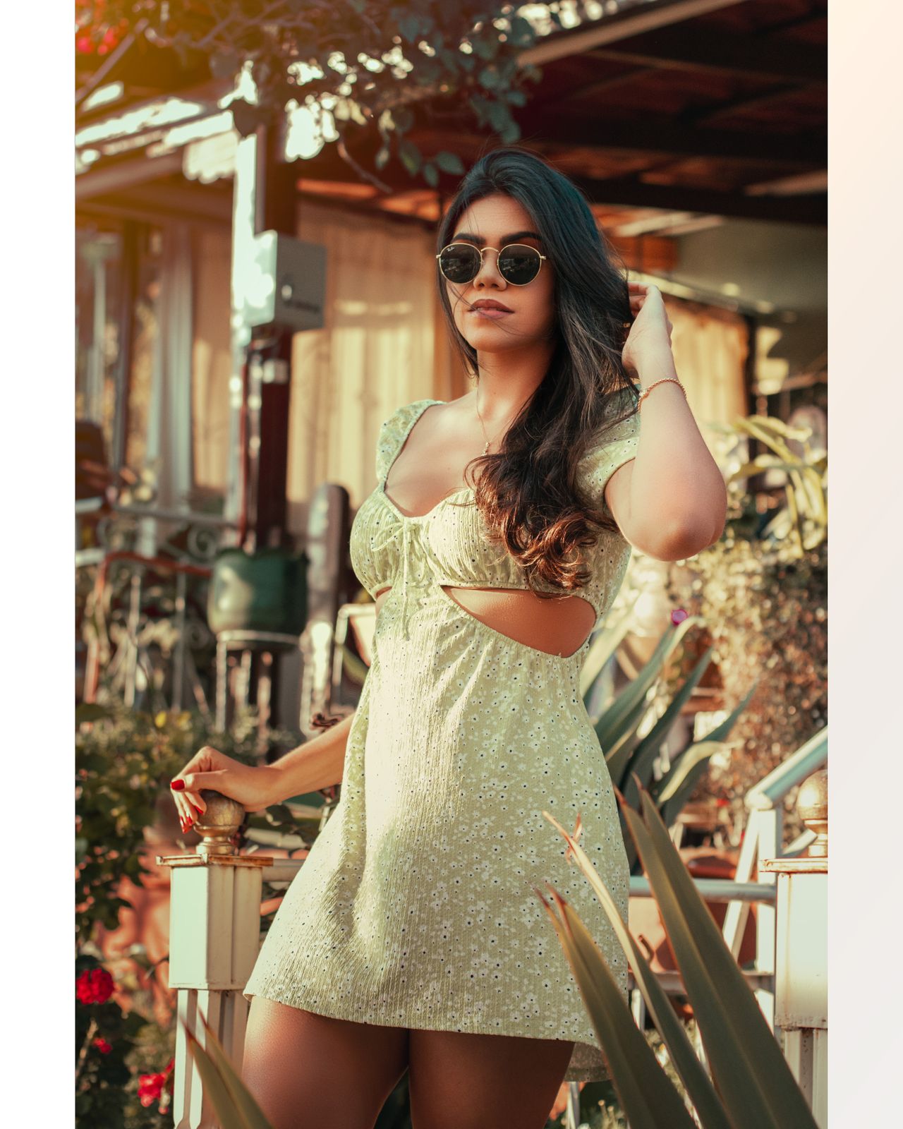 Woman in a light green floral babydoll mini dress with sunglasses