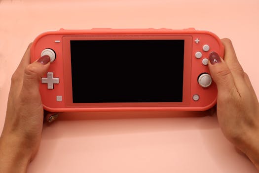 Close-up of hands holding a pink Nintendo Switch Lite, perfect for gaming or tech visuals.