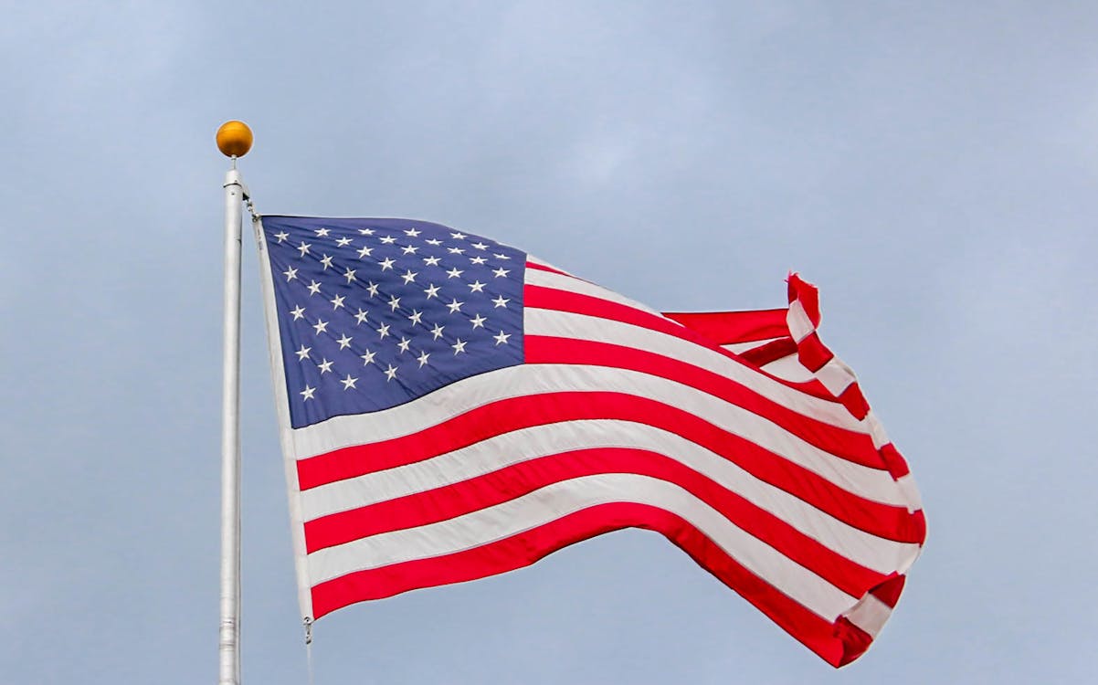 Free Usa Flag Waving On White Metal Pole Stock Photo