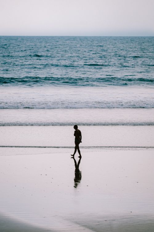 Silhouette of Woman Walking on Beach · Free Stock Photo