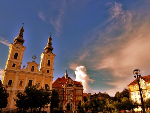 Free Beautiful baroque church and city buildings under a vibrant evening sky, perfect for travel and architecture themes. Stock Photo