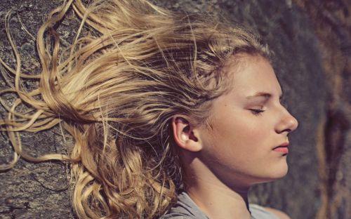 Free Close-up portrait of a young woman with flowing blonde hair in natural light. Stock Photo