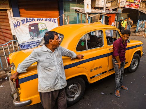 Two Men Standing in Front of a Taxi