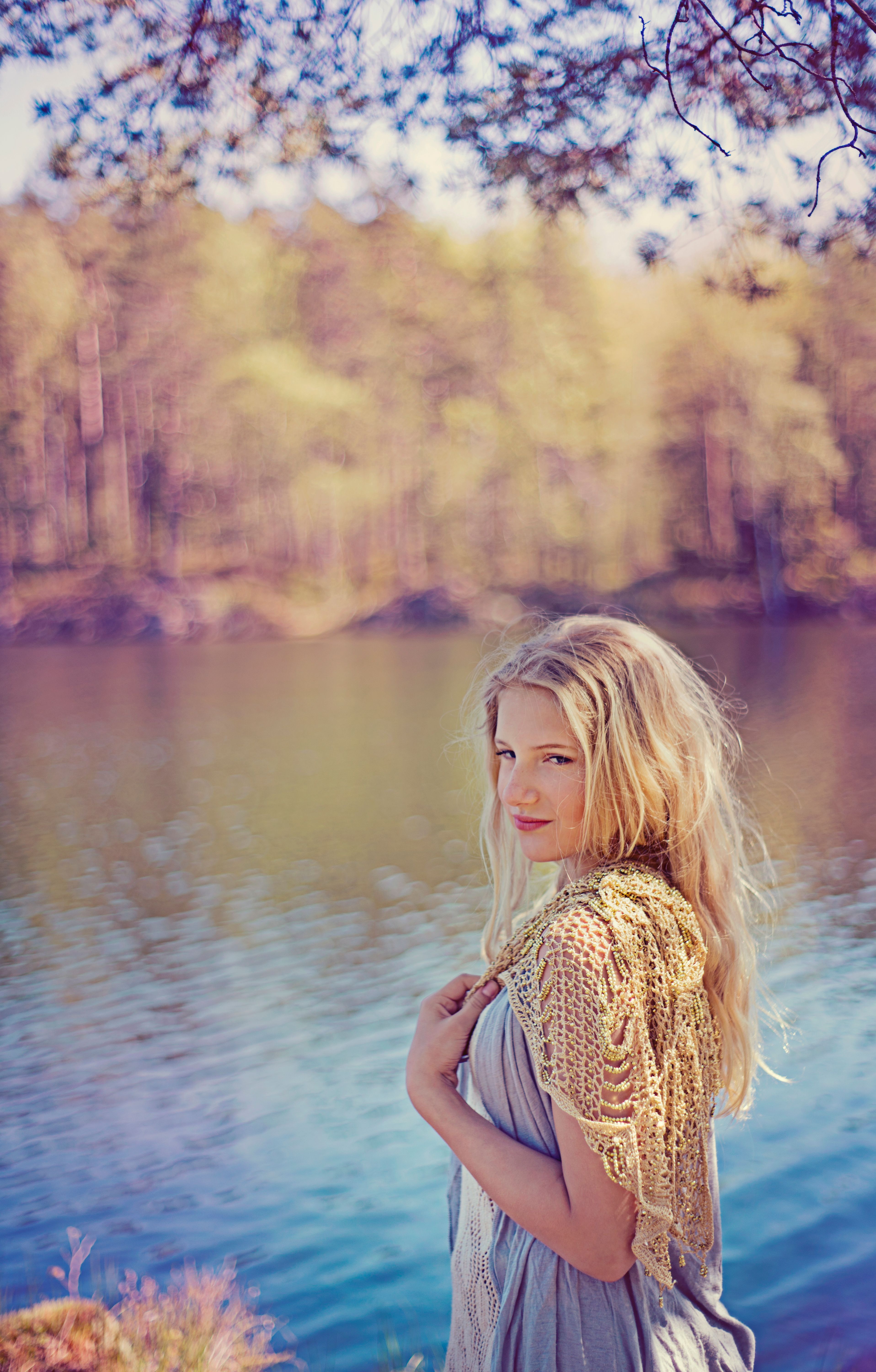 A young woman enjoying a peaceful moment by a scenic lake during summer.