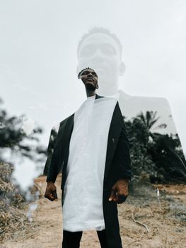 Artistic double exposure of a well-dressed man in formalwear standing outdoors.