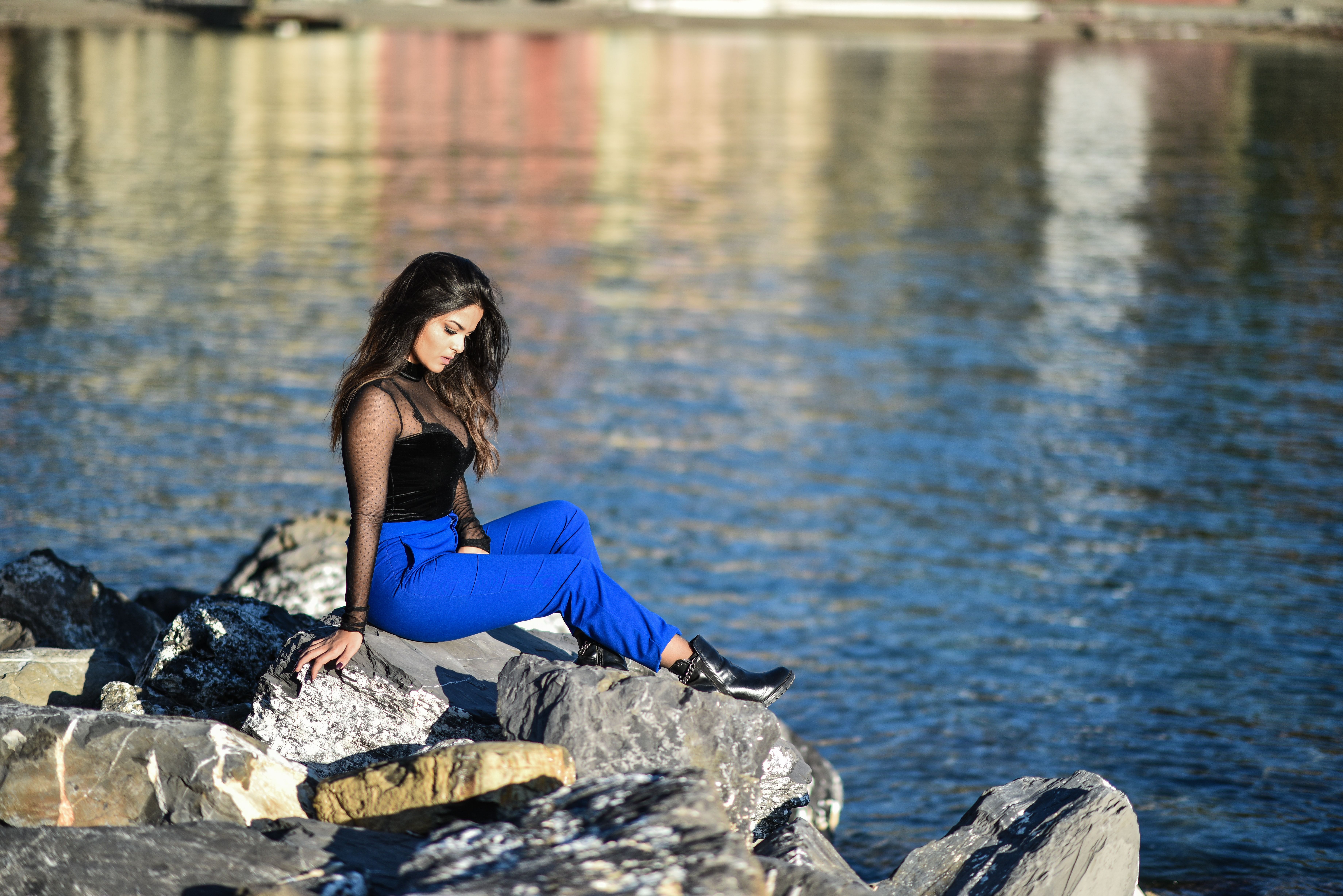 Woman Sitting on Sea Rocks · Free Stock Photo