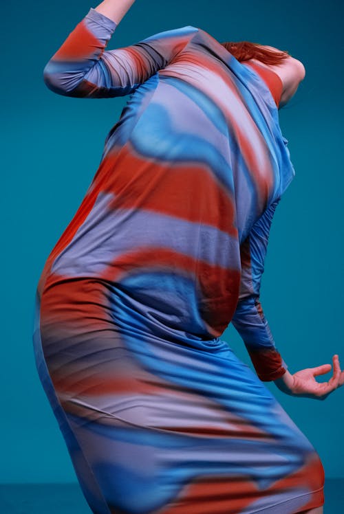 Woman in Fitting Dress Posing on Blue Backg