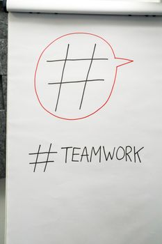 A poster in an office setting highlighting teamwork with a hashtag symbol.