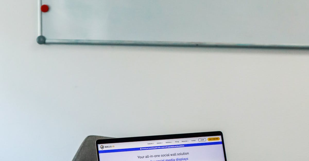 A modern office setup featuring a laptop and a whiteboard schedule for social media platforms.