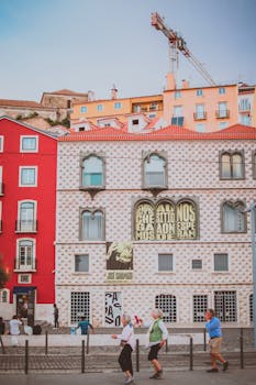 里斯本迷人的传统建筑沐浴在明媚的阳光下，行人走过