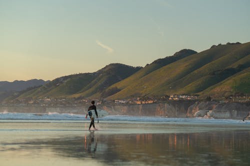 Surfer Walking along Beach