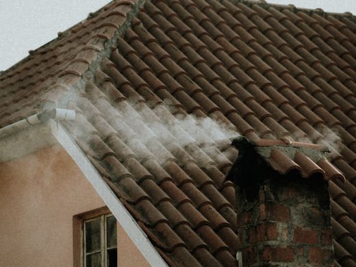 Copertura con camino e manto di tegole di un edificio residenziale