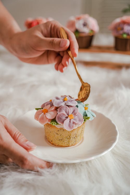 Woman Holding a Cupcake with Flowers 