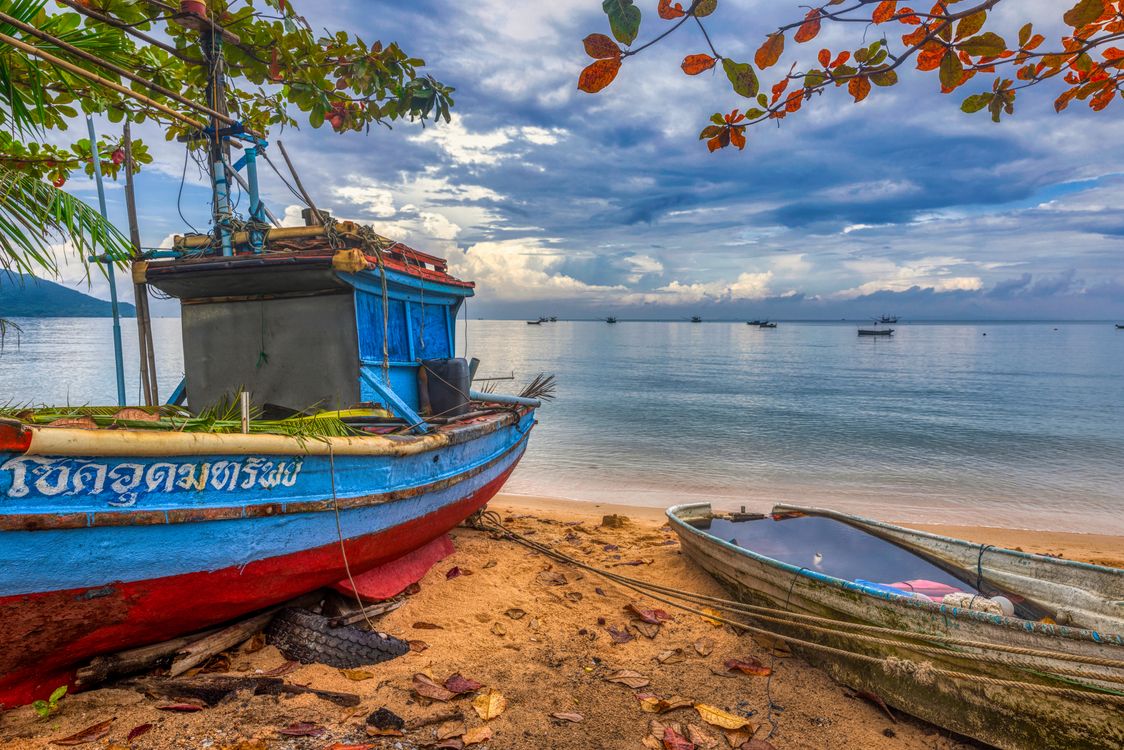 Colourful Thai fishing boats moored on a quiet sandy beach