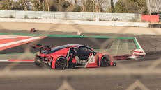 一辆红色跑车在户外赛道上疾驰的特写镜头，捕捉了速度与激情