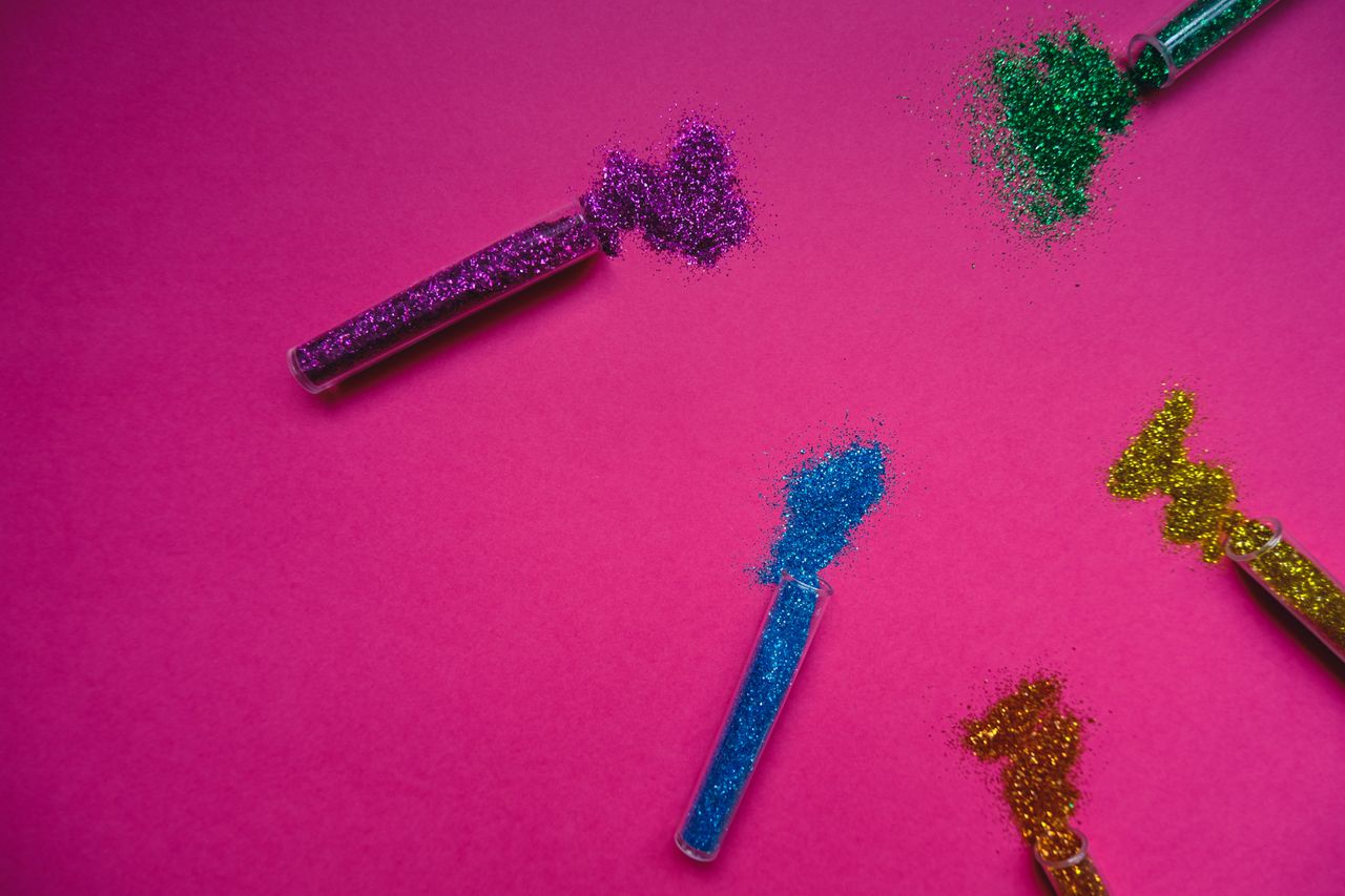 vibrant glitter of various colors spilled from test tubes on a bright