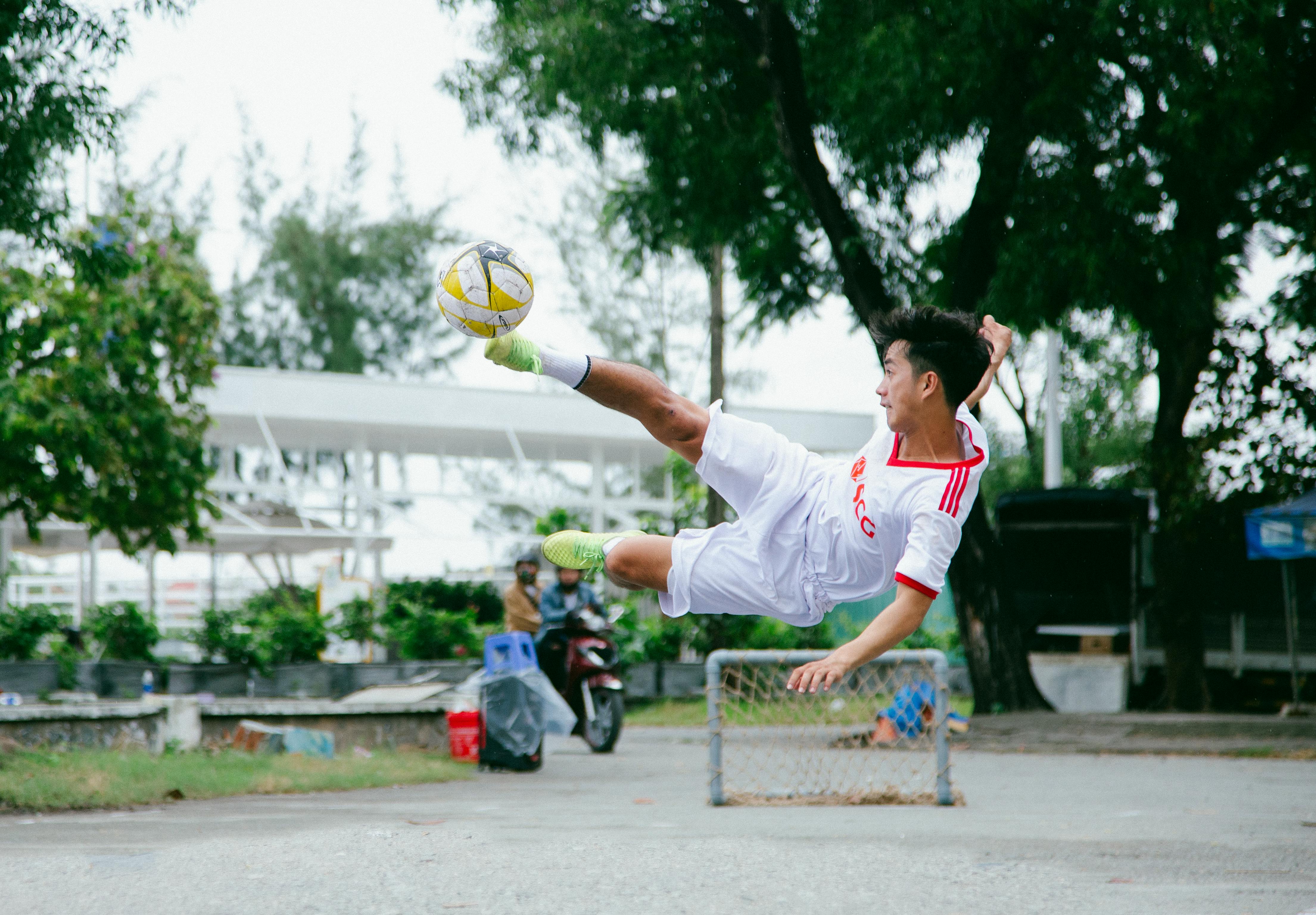 time lapse photography of soccer player jumping kicking ball
