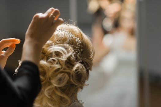 Close-up of a stylish bridal hairstyle being adjusted with intricate accessories.