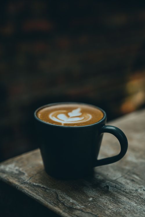 Free A close-up of a cappuccino with latte art in a rustic setting in Bogor, Indonesia. Stock Photo