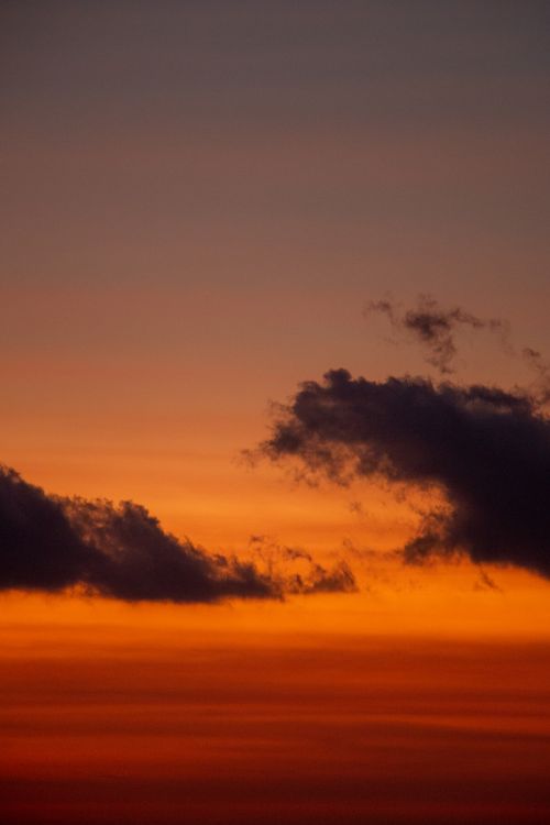 Free Captivating sunset with dramatic clouds and vibrant orange hues, perfect for serene backdrops. Stock Photo