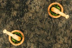 Aerial view of wooden mortars and pestles filled with fresh green pesto.