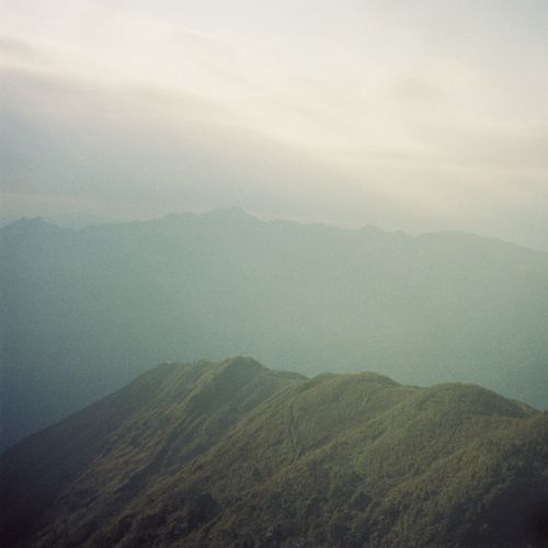 Free A tranquil view of a mountain range enveloped in morning fog, capturing calmness and beauty. Stock Photo
