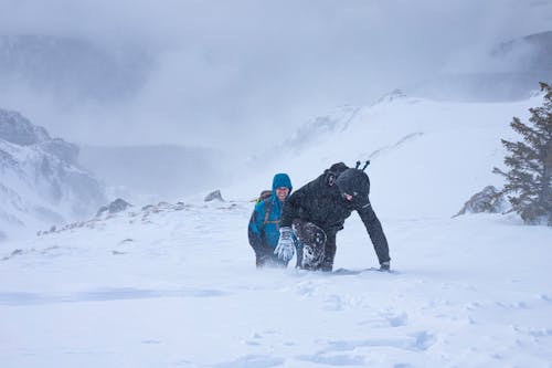 Men Climbing in Snow on Mountain