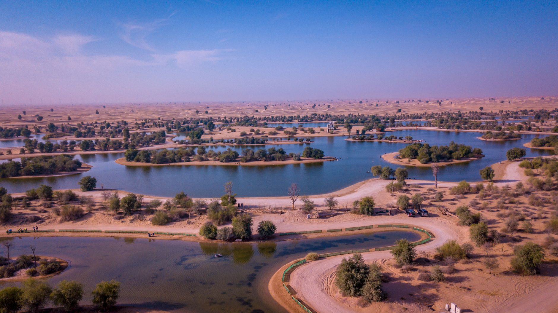Stunning aerial shot of tranquil desert oasis with scenic lakes and greenery.