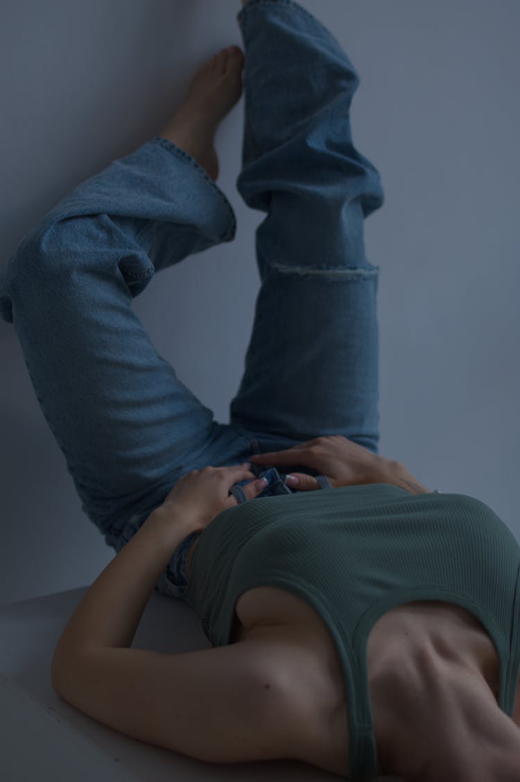 Woman In Jeans With Legs On Wall