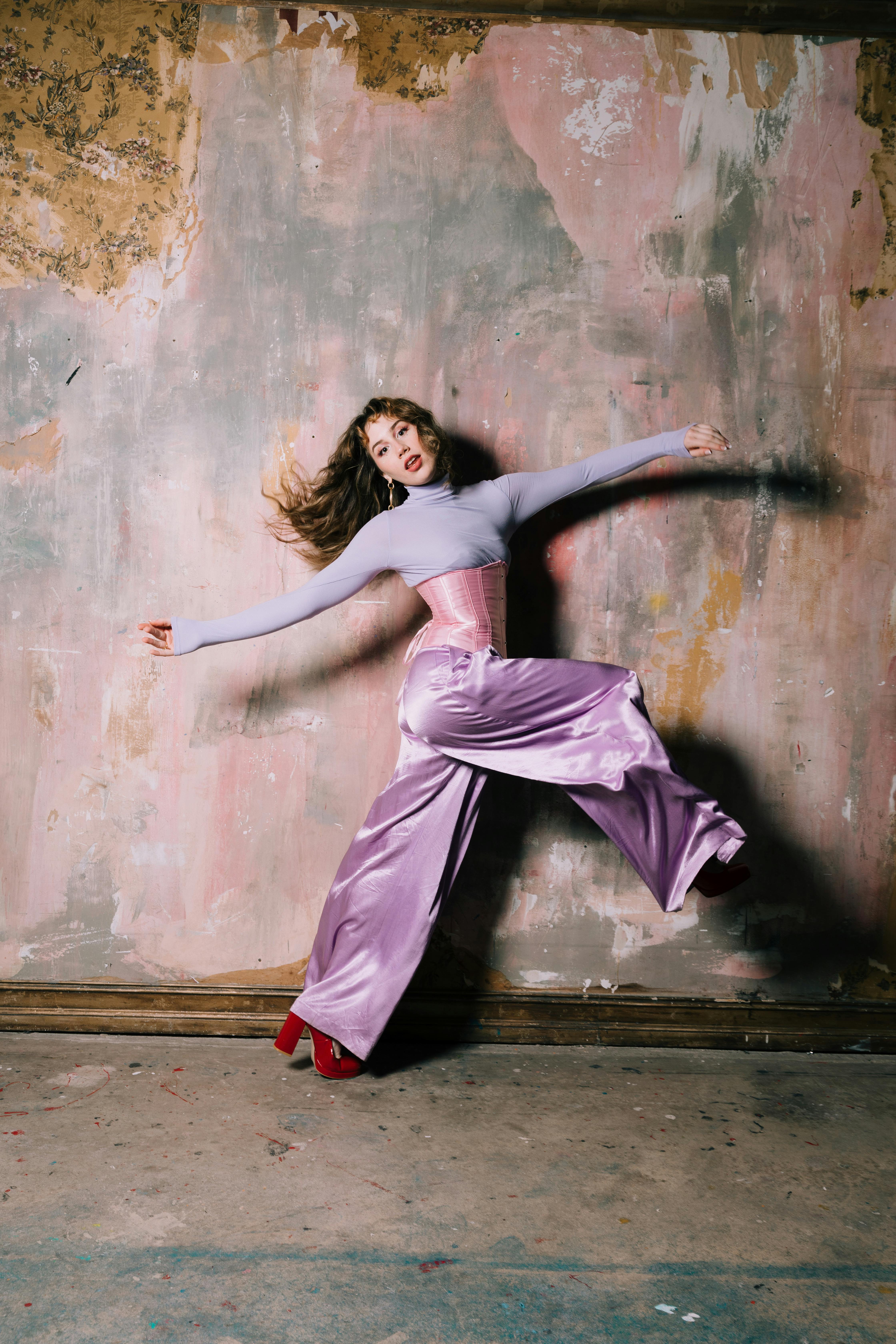Bold fashion statement with model in oversized pants posing against textured wall in Orlando.