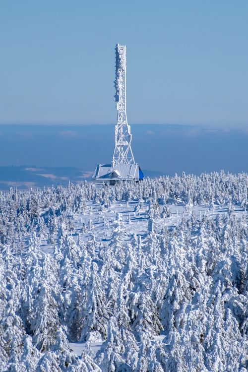 Free A stunning aerial view of a satellite tower surrounded by a snow-covered forest in Świeradów-Zdrój, Poland. Stock Photo