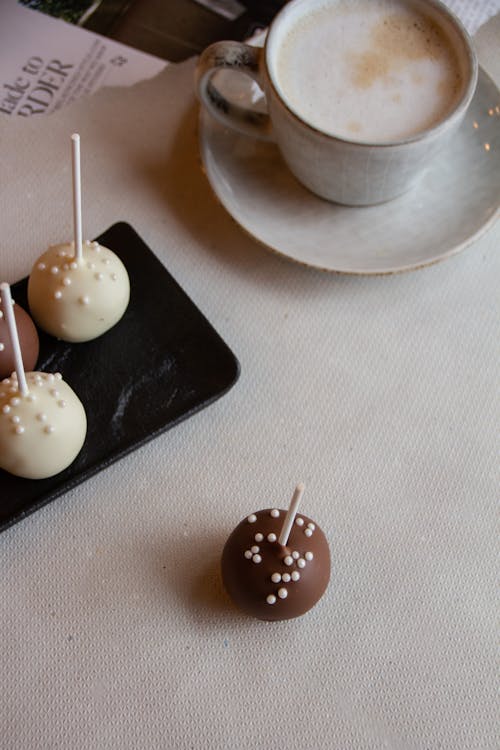 Free Chocolate Ball-Shaped Candies and Coffee Cup on Table Stock Photo