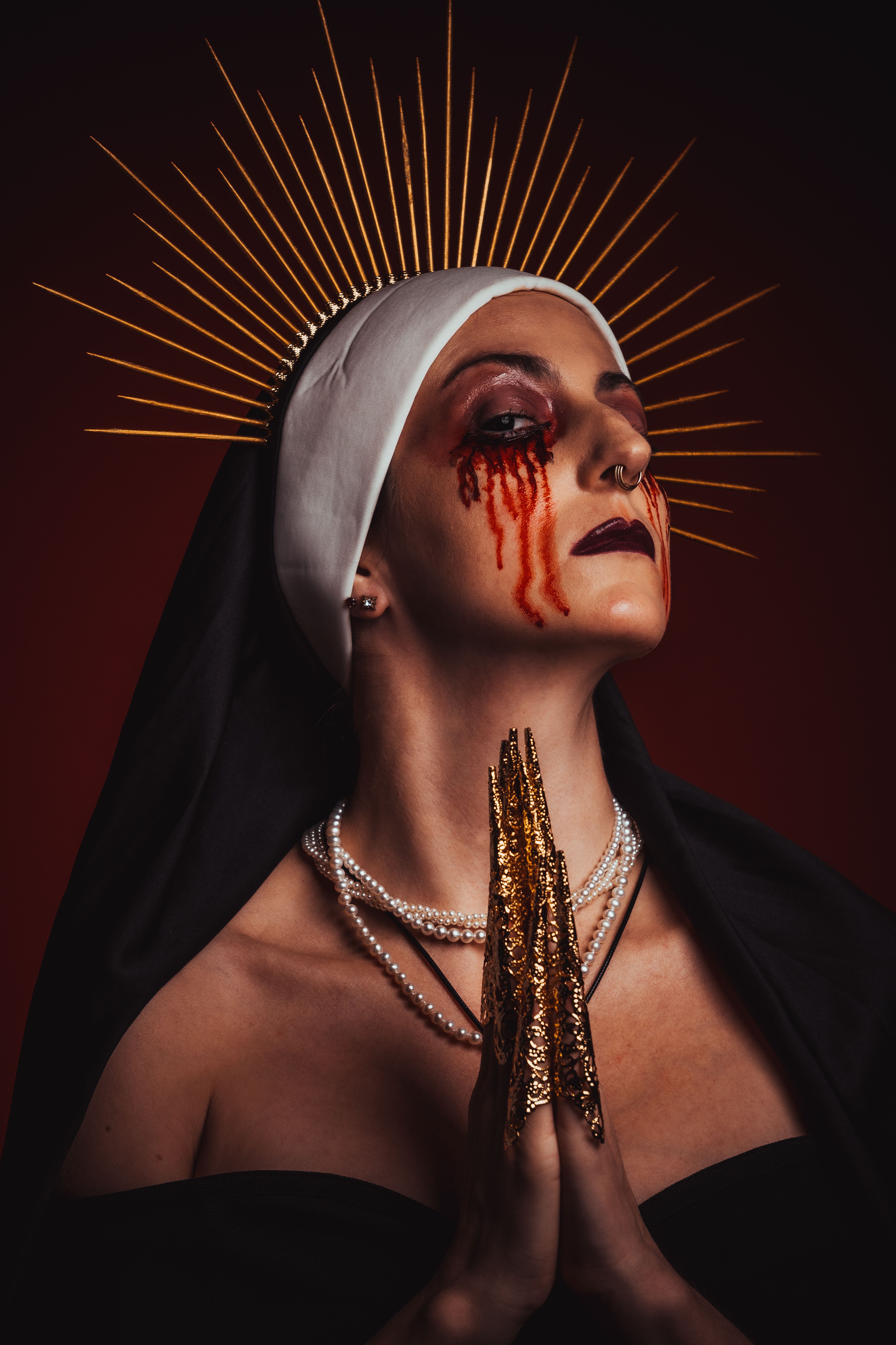 Gothic-style nun with dramatic makeup, featuring distinctive facial designs and golden halo effect.