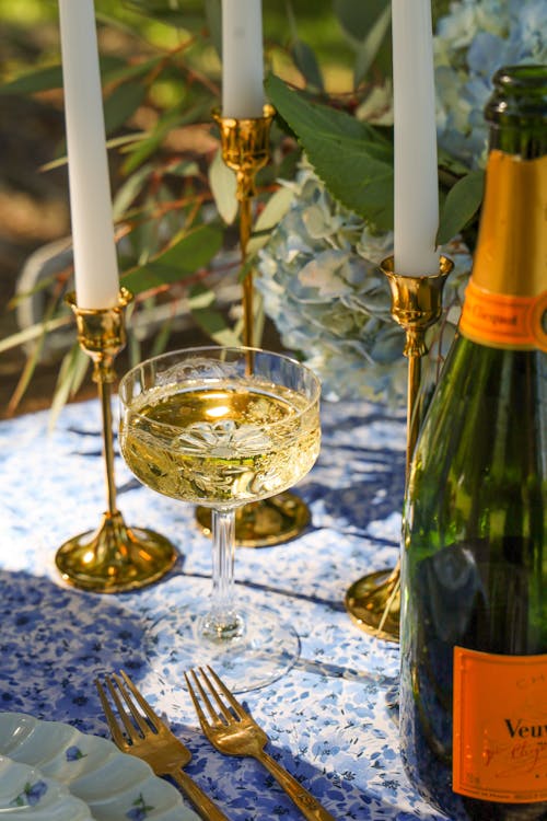 Close-up of Wine Bottle, Glass and Candles on a Table Standing Outside 