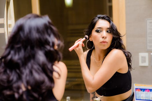 Brunette woman enhancing her look with makeup in a stylish indoor setting.