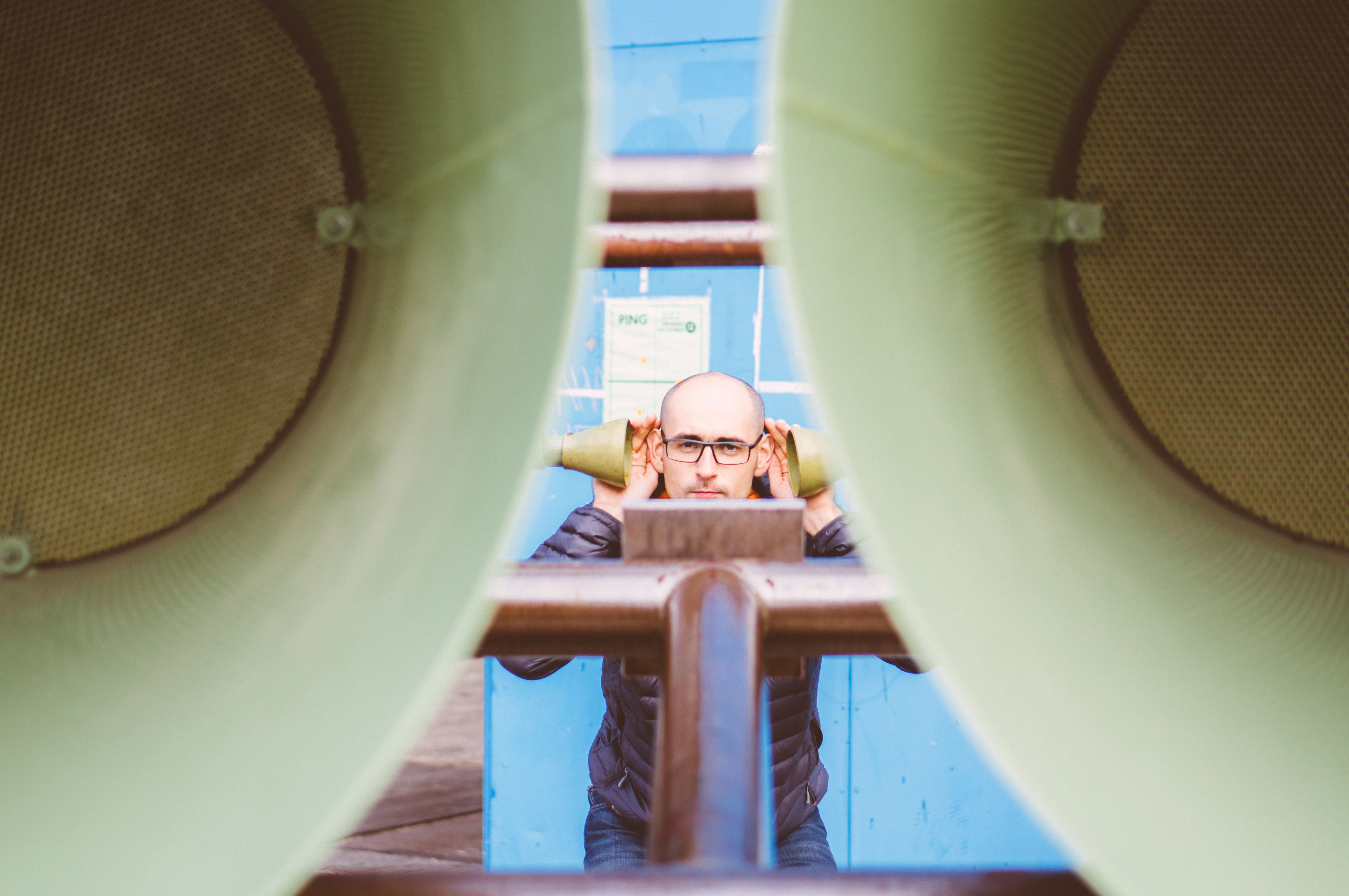 Unique photograph of a man framed by large speakers in Amsterdam, exploring sound and perspective.