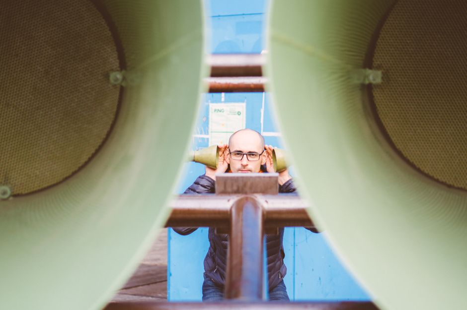 Unique photograph of a man framed by large speakers in Amsterdam, exploring sound and perspective.