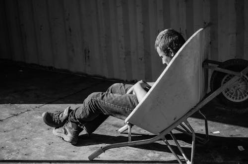 Sitting Man Sleeping in a Wheelbarrow