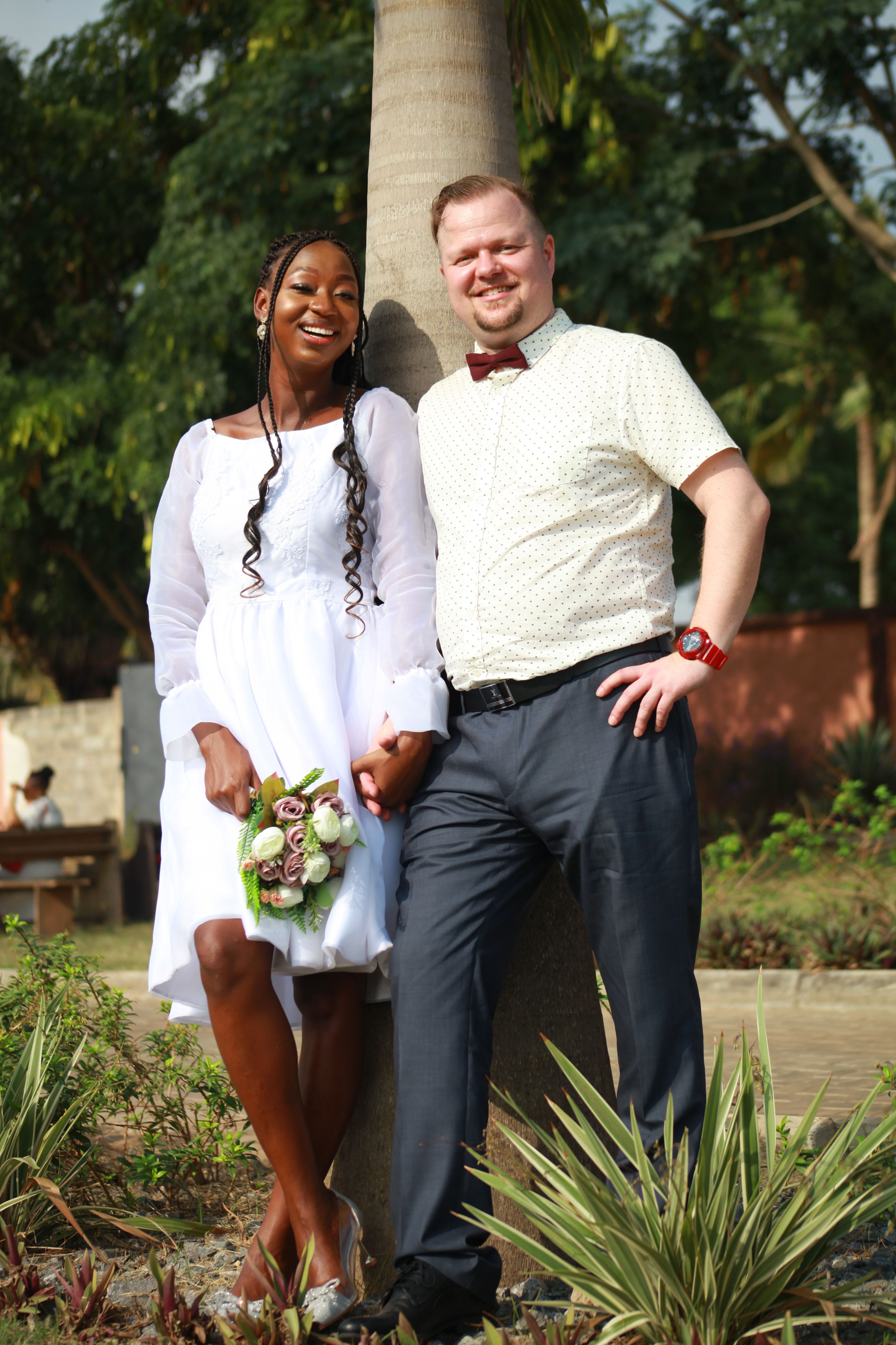 Bride and Groom Standing under a Palm Tree and Smiling · Free Stock Photo
