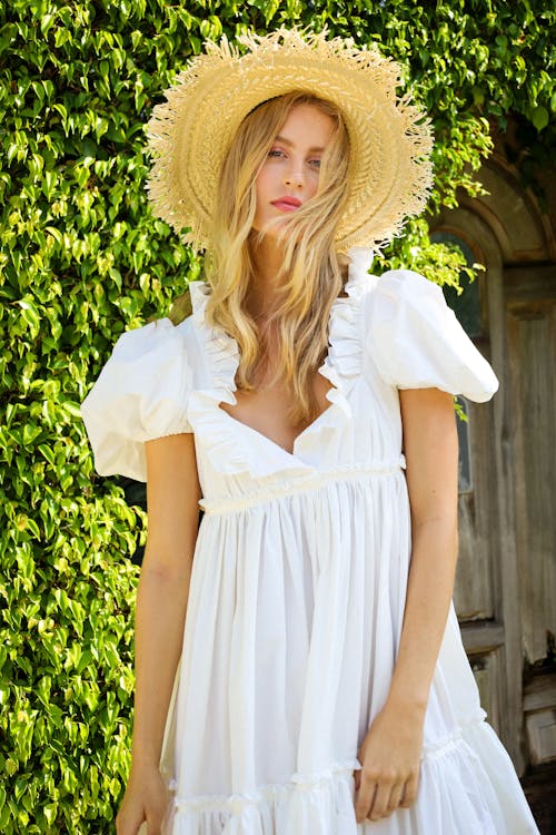 Standing Woman in Light Dress and Straw Hat