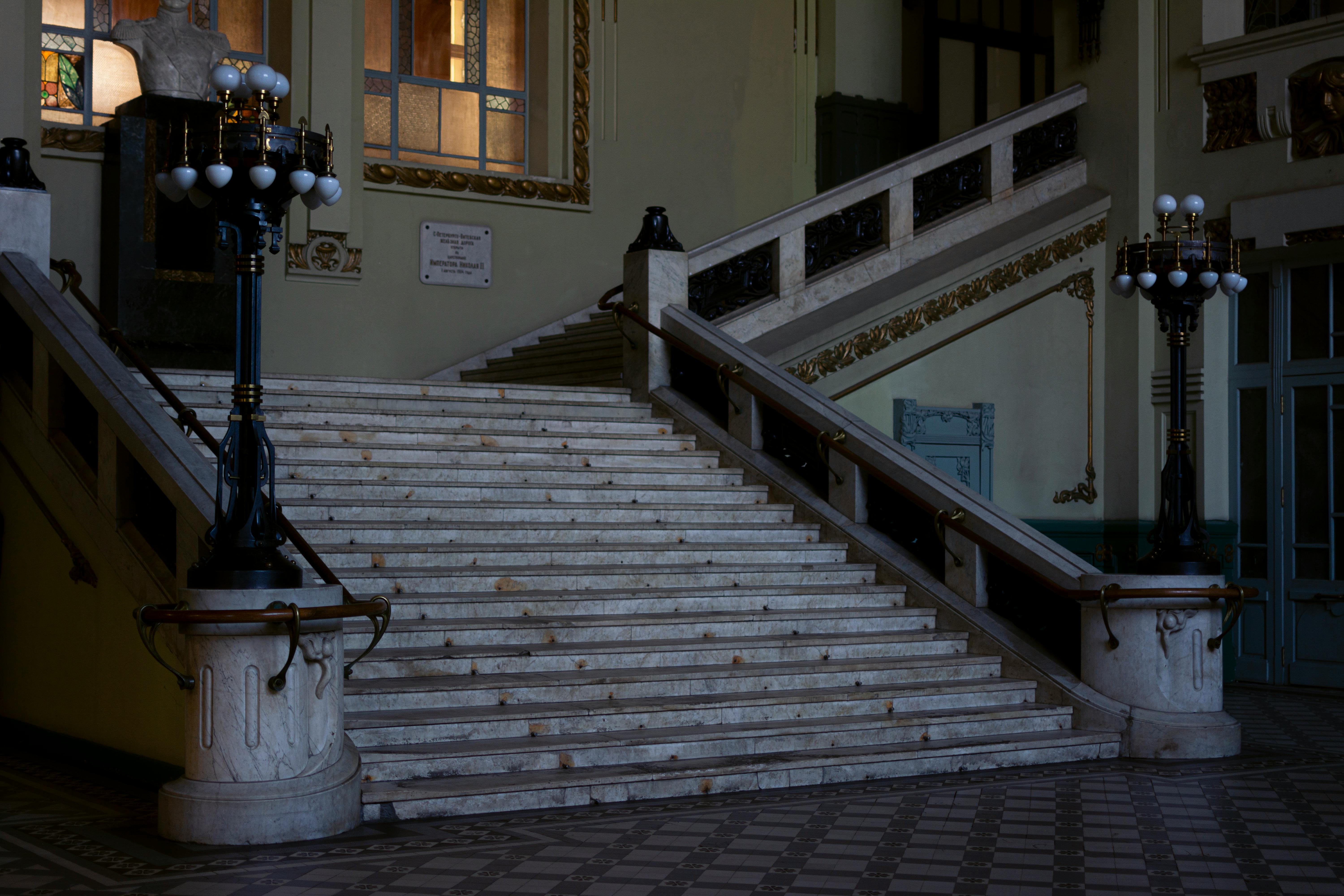 Gran Hotel Inglés: Grand staircase with ornate lamps and detailed Art Deco architecture, evoking luxury and romance.