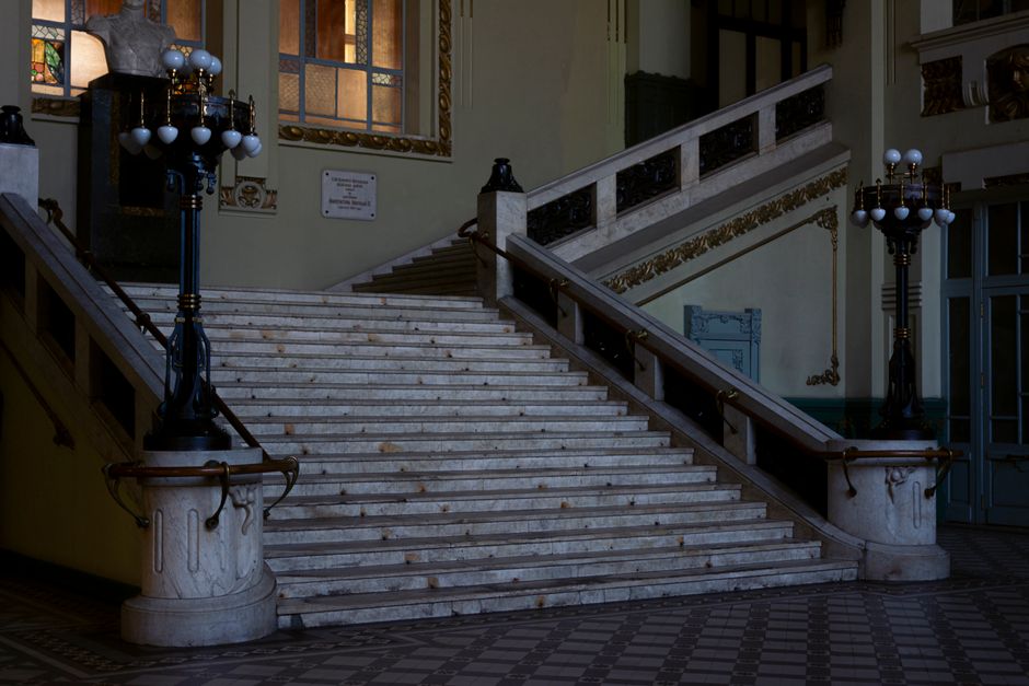 Gran Hotel Inglés: Grand staircase with ornate lamps and detailed Art Deco architecture, evoking luxury and romance.