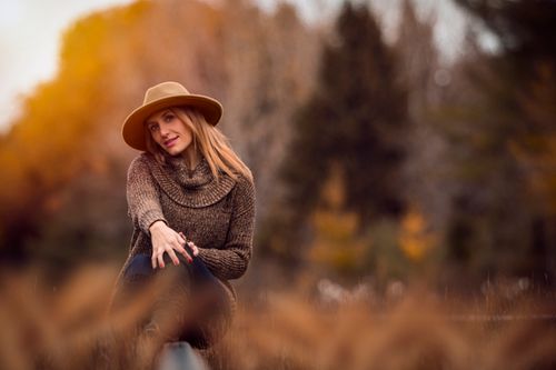 Free A vibrant autumn portrait of a smiling woman in a hat, enjoying the outdoors in a knitted sweater. Stock Photo