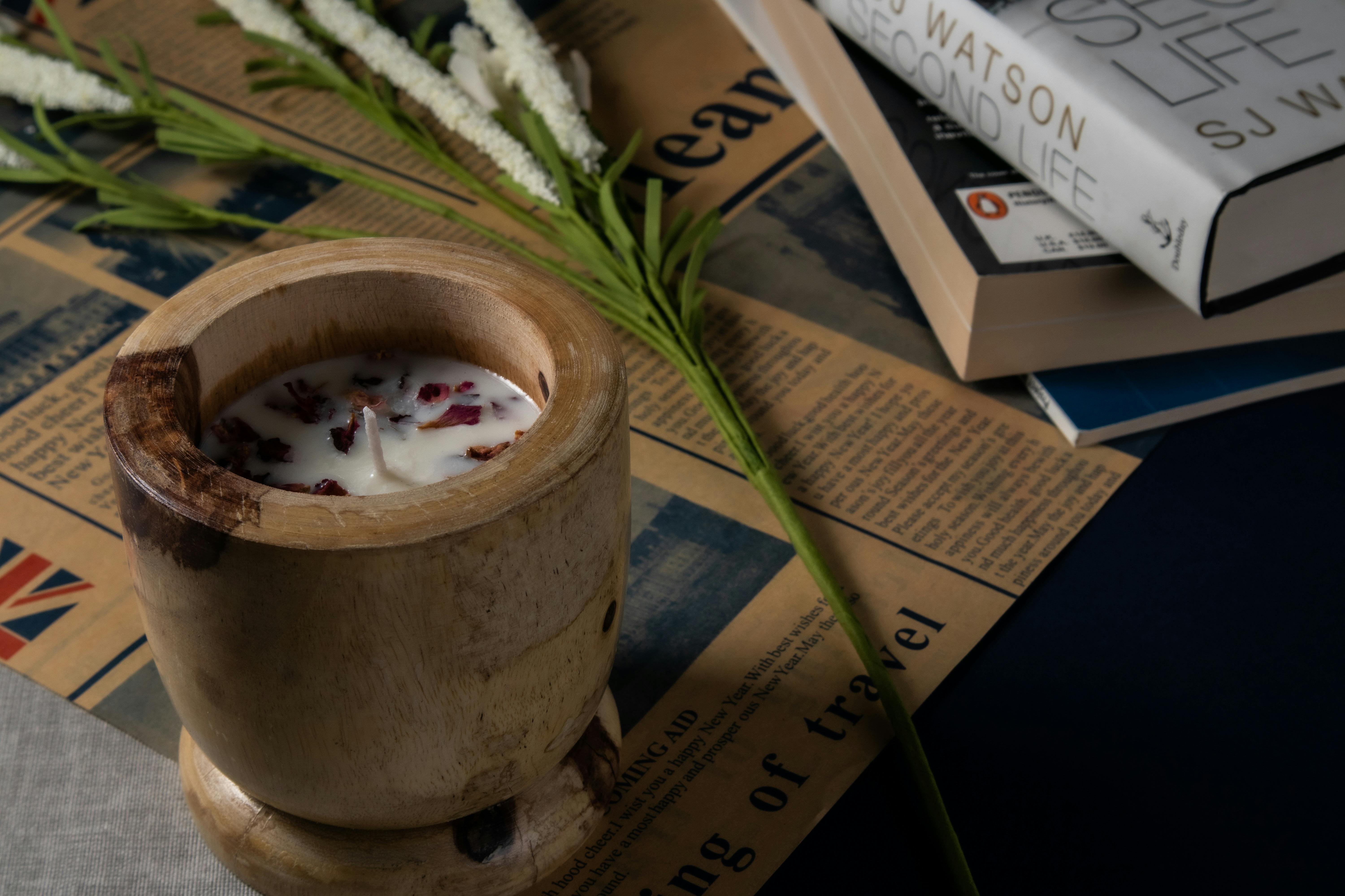 A wooden cup with a candle and flowers on top